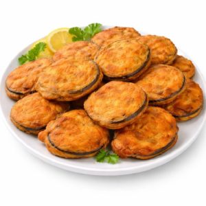 Une assiette blanche avec BAIGAN PAKORA (Minimum de commande 10 pièces) dorée, garnie de coriandre fraîche et d'une tranche de citron sur le côté.