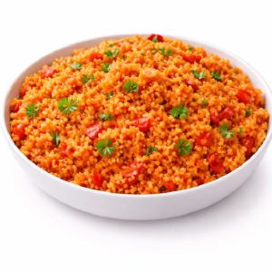Un bol blanc rempli de BOULGHOUR À LA TOMATE (accompagnement), composé de boulgour cuit mélangé à des tomates, garni de persil. Commande minimum : 5 portions (250g/portion). Sur fond blanc.