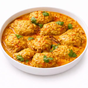 Un bol blanc rempli de POULET AU BEURRE (300g) dans une sauce crémeuse à l'orange, garni de feuilles de coriandre fraîche.