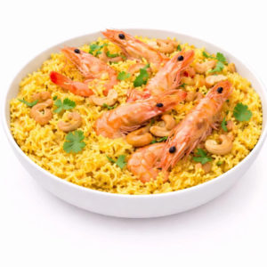 Une portion de CREVETTES BIRIYANI (300g) comprenant du riz jaune, des crevettes entières, des noix de cajou et de la coriandre fraîche dans un bol blanc sur fond blanc.