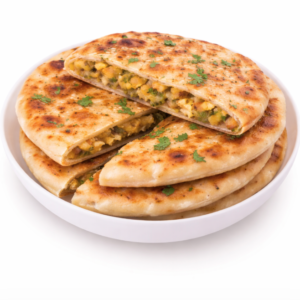 Un bol blanc contient de la PARATHA farcie (Pièce), tranchée pour révéler une farce de pommes de terre et de petits pois épicés, garnie de coriandre fraîche.