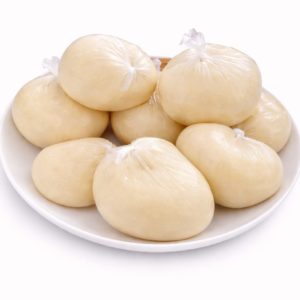 Sur une assiette blanche, plusieurs portions de 200 g de PLACALI sont enveloppées dans des sacs en plastique transparents et nouées en haut, formant des formes lisses et arrondies. Le fond est blanc.