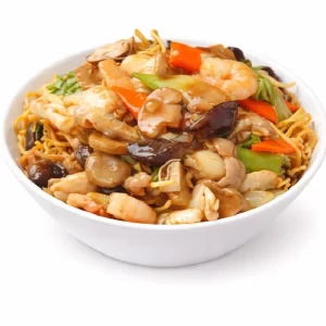 Un bol blanc rempli de Poulet aux Champignons (250g/pers), composé de nouilles croustillantes, de crevettes, de champignons, de carottes, de légumes verts et d'une sauce brune brillante.