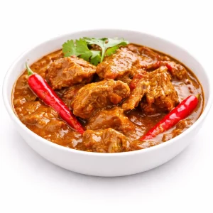 Un bol blanc de curry AGNEAU MADRAS (300g) avec de tendres morceaux de viande, garnis de deux piments rouges et de coriandre, sur fond blanc.
