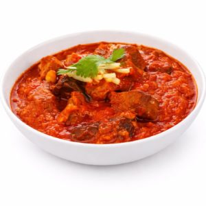 Un bol blanc d'AGNEAU VINDALOO (300g) avec de tendres morceaux de viande dans un riche curry rouge, garni de coriandre fraîche et de fromage râpé, sur un fond blanc uni.