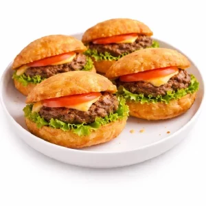 Sept MINI BOKIT GARNI BOEUF (80g chacun), fourrés au bœuf, à la laitue, à la tomate et au fromage dans des petits pains dorés croustillants, sont disposés sur une assiette ronde blanche sur fond blanc. Commande minimum : 7 pièces.