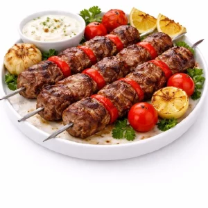 BROCHETTE DE BOEUF CUITE AU FEU DE BOIS (Barquette de 10 pièces) : dix brochettes de bœuf grillées au feu de bois, servies avec tomates et poivrons rôtis, citron, persil frais, ail grillé, tomates cerises et une sauce crémeuse.