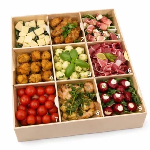 Le "COFFRET ITALIEN MAMA MIA ! (pour 8/10 Pers)" est une boîte composée de neuf sections, chacune proposant des amuse-gueule italiens tels que des cubes de fromage, des ailes de poulet, des brochettes, de la charcuterie, de la salade de courgettes, des bouchées frites, des tomates cerises, des crevettes et des poivrons farcis.