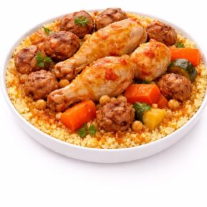 COUSCOUS CUISSE DE POULET ET BOULETTES DE POULET : Un bol de couscous coloré avec des pilons de poulet, des boulettes de viande de poulet, des pois chiches, des carottes, des courgettes, des herbes fraîches et une sauce savoureuse.