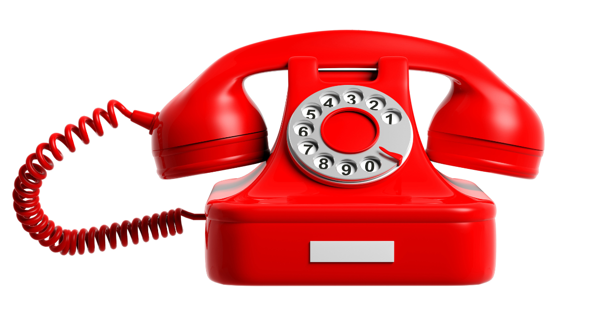 Un téléphone à cadran rotatif rouge vif avec un cordon enroulé, vu de face sur un fond blanc.