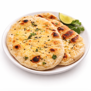 Trois morceaux de Butter Nan, garnis d'herbes, sont servis sur une assiette blanche et accompagnés d'une tranche de citron vert et d'un brin de coriandre.