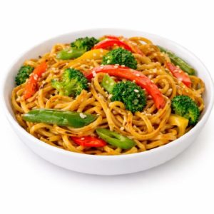 Une portion de NOUILLES SAUTÉES (200g/pers) avec des nouilles, du brocoli, des poivrons rouges et jaunes, des pois mange-tout et des graines de sésame dans un bol blanc sur fond blanc.