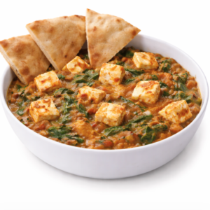 Un bol blanc de PALAK PANEER (250 g), composé de cubes de paneer dans un curry d'épinards crémeux, est servi avec trois morceaux de pain naan.