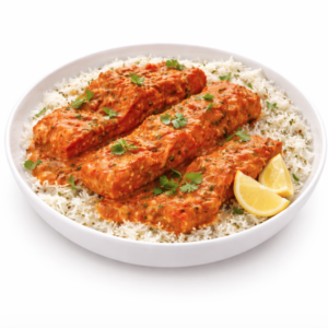 SAUMON TIKKA MASALA (300g) : Riz blanc garni de trois morceaux de saumon dans une sauce crémeuse à l'orange, agrémenté de coriandre fraîche et servi avec deux quartiers de citron.