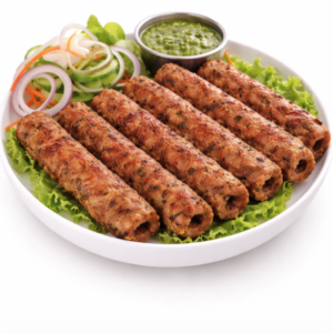 Une assiette de SEEKH KEBAB (300g) servie sur de la laitue avec des tranches d'oignon et de concombre, plus un bol de chutney vert.